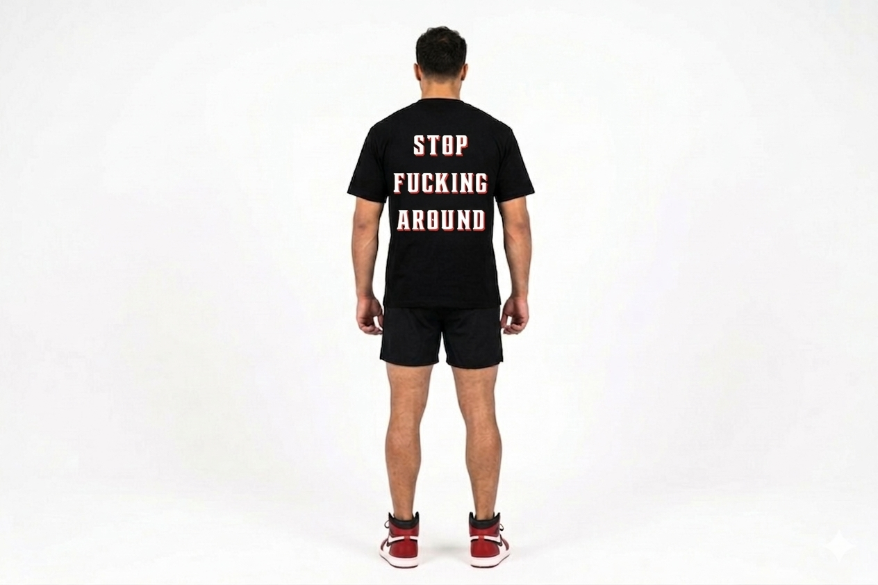 Person wearing a black t-shirt with text on the back, standing against a white background