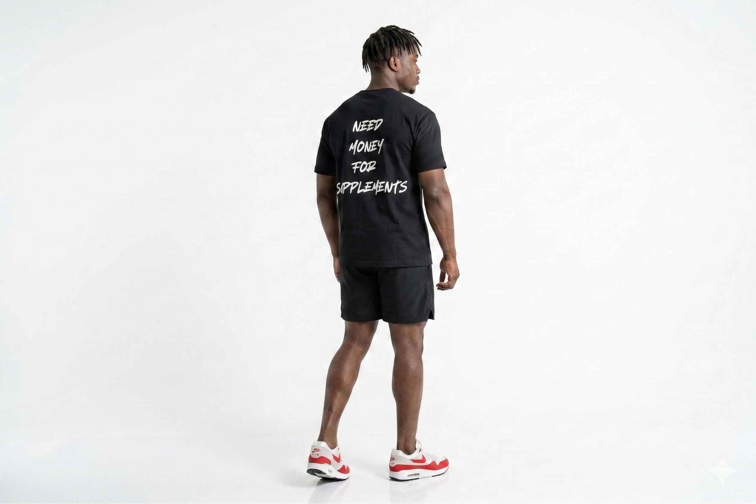Person wearing a black t-shirt with text on the back, standing against a white background