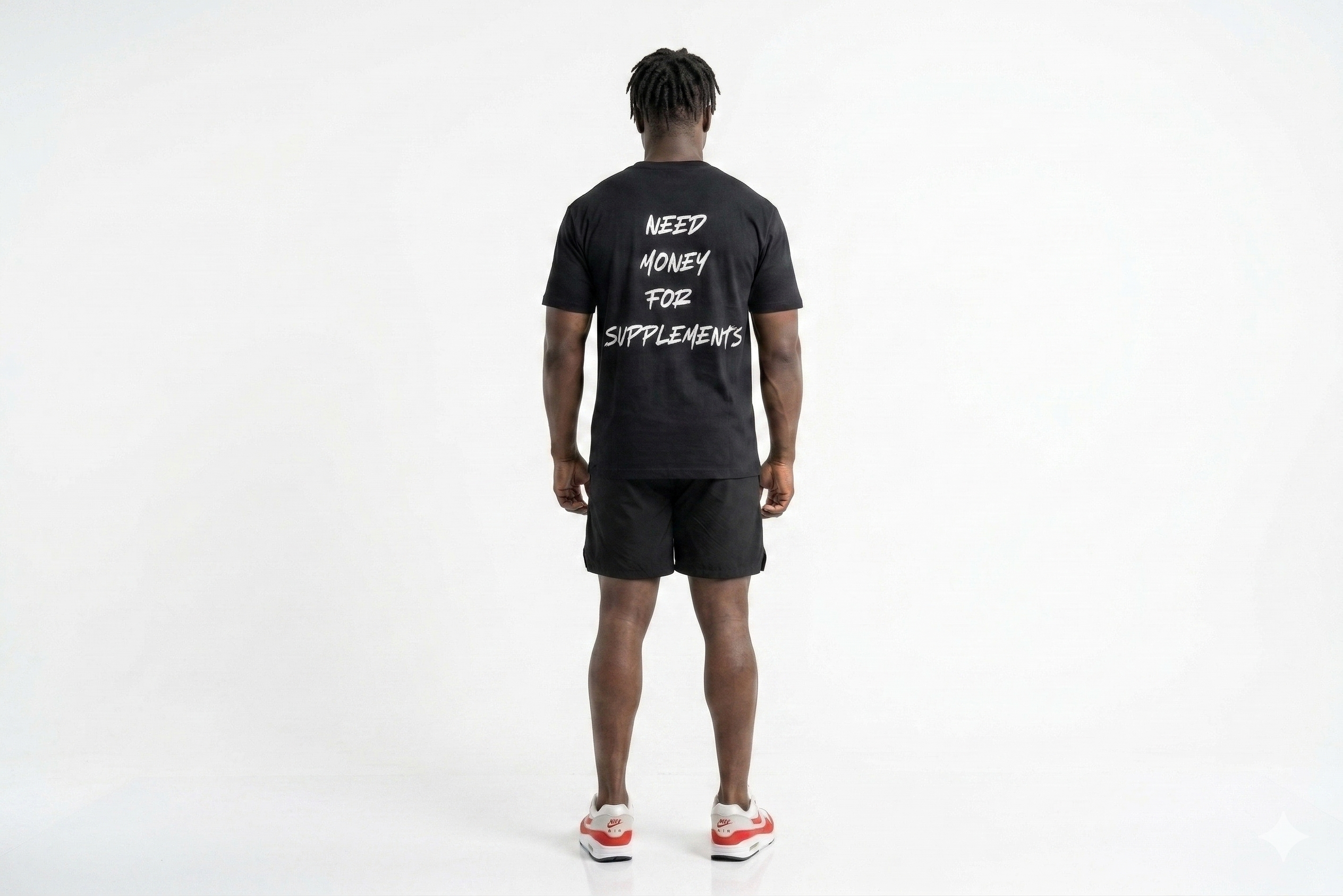 Person wearing a black t-shirt with text on the back, standing against a white background