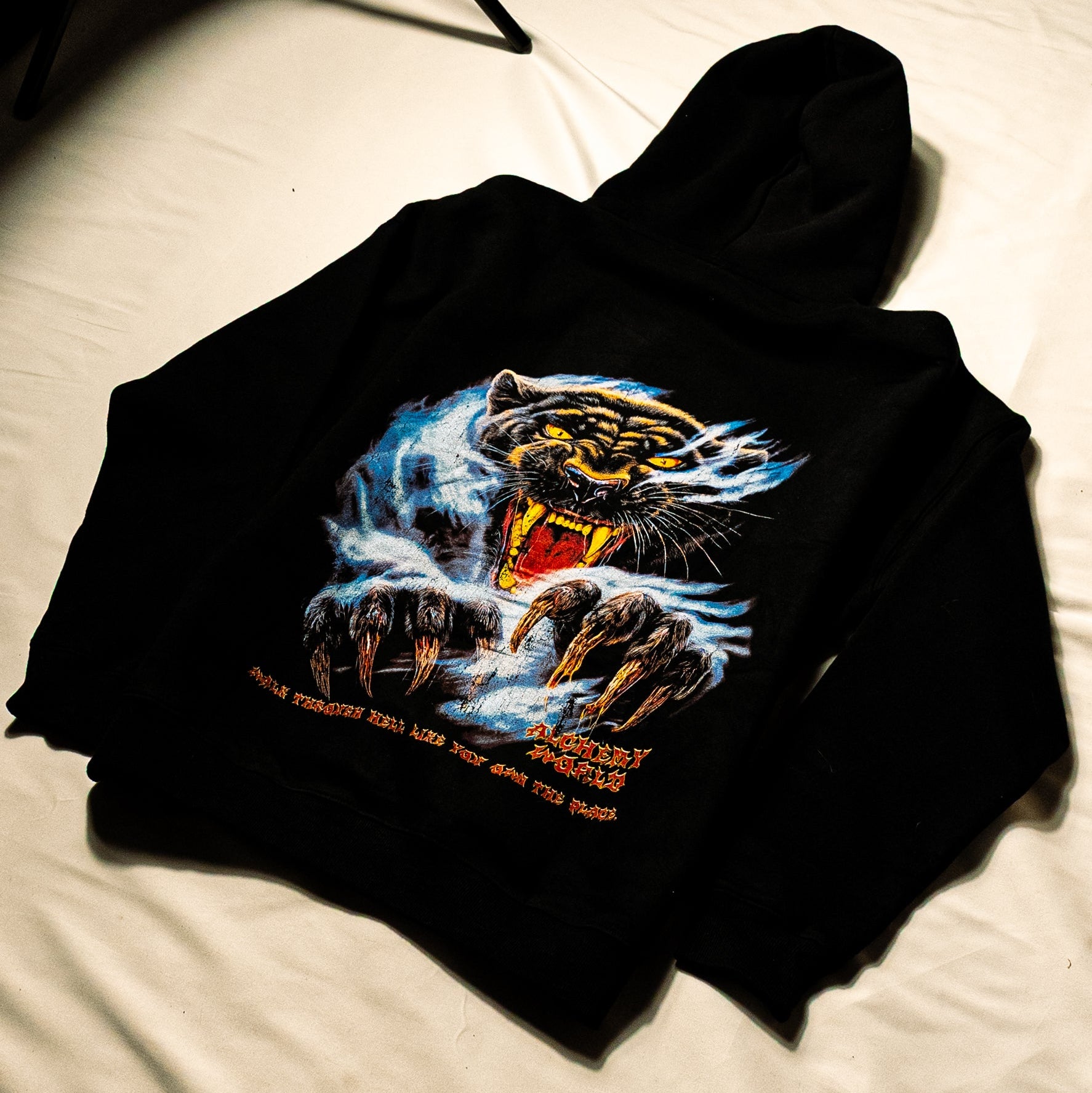 Black hoodie with a panther graphic on a white surface